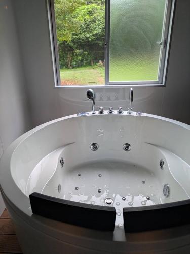 a bath tub in a bathroom with a window at niko villa 伊豆高原Woody棟 in Ito