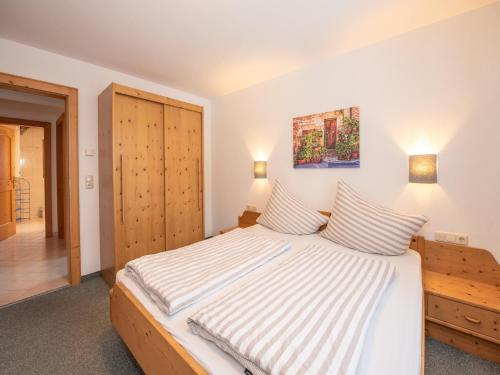 a bedroom with a large bed with striped sheets at Apartment in Wald near Krimml Waterfalls in Wald im Pinzgau