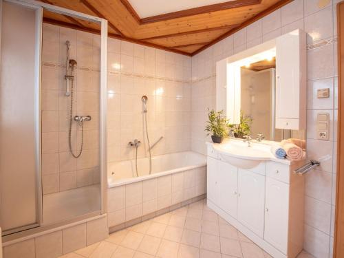 a bathroom with a shower and a sink and a tub at Apartment in Wald near Krimml Waterfalls in Wald im Pinzgau