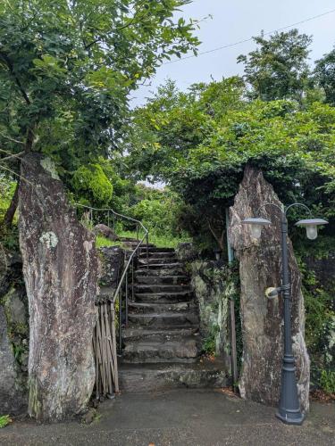 a stairway leading up to a set of stone stairs at niko villa 伊豆高原Woody棟 in Ito