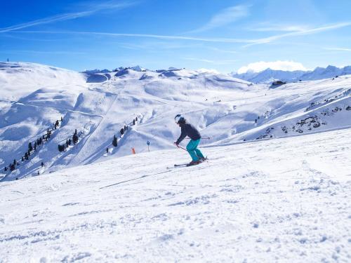 a person is skiing down a snow covered mountain at Apartment in Wald near Krimml Waterfalls in Wald im Pinzgau