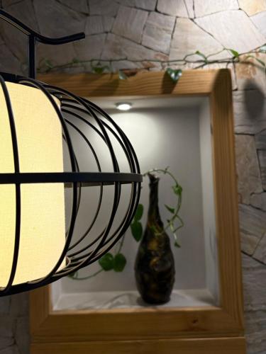 a vase sitting on a shelf with a lamp at Vastu Boutique Hotel in Kathmandu