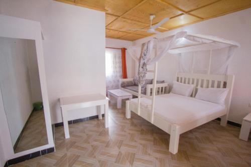 a bedroom with a white bed and a canopy at Havillah Gardens Watamu in Watamu