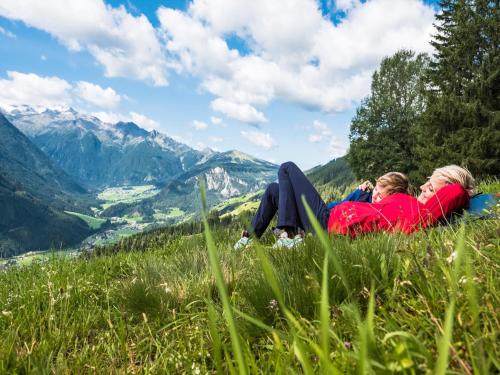 two women laying in the grass on a mountain at Apartment in Wald near Krimml Waterfalls in Wald im Pinzgau