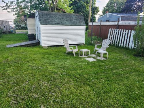 a yard with two chairs and a shed at Cozy Sim's in Moncton