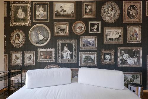 a bedroom with a wall of pictures and a bed at Villa Amelia in Orta San Giulio