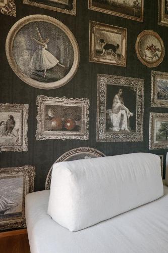 a bedroom with a wall of pictures and a bed at Villa Amelia in Orta San Giulio