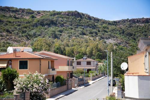 a street in a town with a mountain in the background at BIG RIVER HOUSE, Fronte Temo in Bosa Marina
