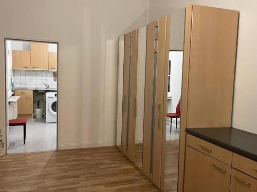 cocina con armarios de madera y sala de estar. en New Living Nest, en Seevetal