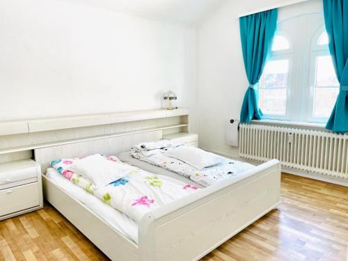 Cama blanca en habitación con cortinas azules en New Living Nest, en Seevetal