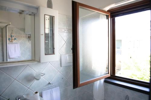 a bathroom with a shower and a glass window at BIG RIVER HOUSE, Fronte Temo in Bosa Marina