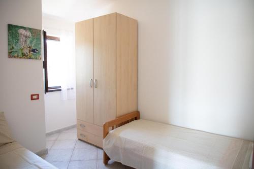 a bedroom with a bed and a wooden cabinet at BIG RIVER HOUSE, Fronte Temo in Bosa Marina