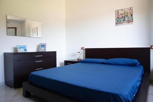 a bedroom with a blue bed and a dresser at BIG RIVER HOUSE, Fronte Temo in Bosa Marina