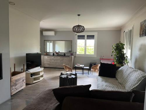 Gîte Nany في نيراك: غرفة معيشة بها أريكة وطاولة