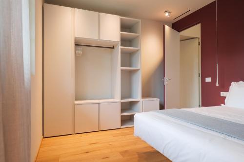 a bedroom with a white bed and a closet at Villa Amelia in Orta San Giulio
