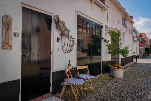 a couple of chairs sitting outside of a building at Elburg-Vesting sfeervol appartement Bij de jufferen in Elburg
