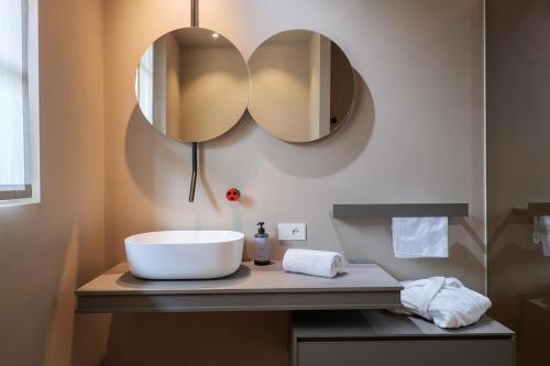 a bathroom with a sink and two mirrors on a counter at Villa Amelia in Orta San Giulio