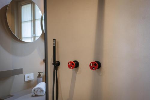 a bathroom with a mirror and red buttons on the wall at Villa Amelia in Orta San Giulio