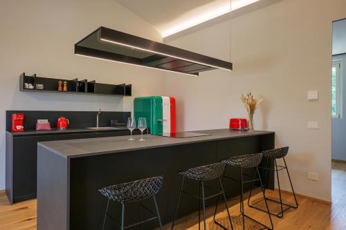 a kitchen with a black counter and stools at Villa Amelia in Orta San Giulio