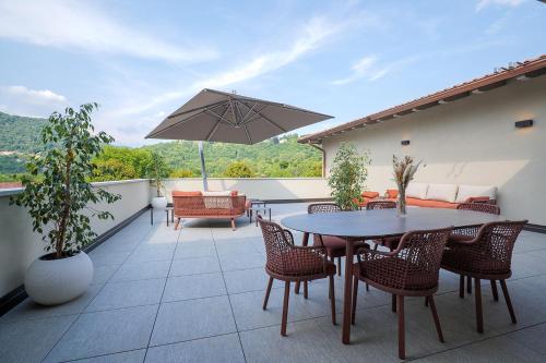 a patio with a table and chairs and an umbrella at Villa Amelia in Orta San Giulio