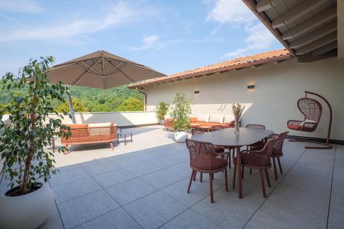 a patio with a table and chairs and an umbrella at Villa Amelia in Orta San Giulio