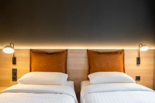 two beds sitting next to each other in a room at Moxy Brussels City Center in Brussels