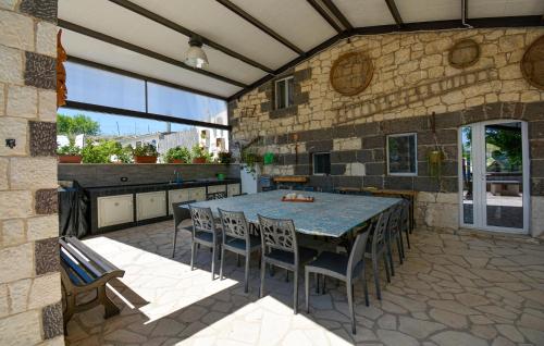 Un patio con mesa y sillas y una cocina. en Stunning Home In Monterosso Almo, en Monterosso Almo