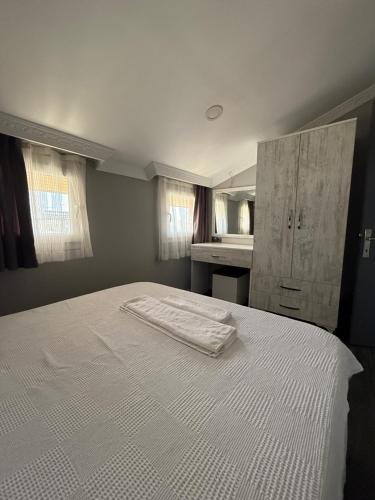 Un dormitorio con una cama blanca y un lavabo. en Eko Homes Fethiye, en Fethiye