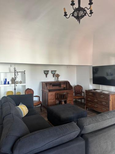 a living room with a couch and a flat screen tv at Solar de Arrayollos by PURUS in Arraiolos
