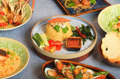 a table topped with plates of food with different foods at Sheraton Can Tho in Can Tho