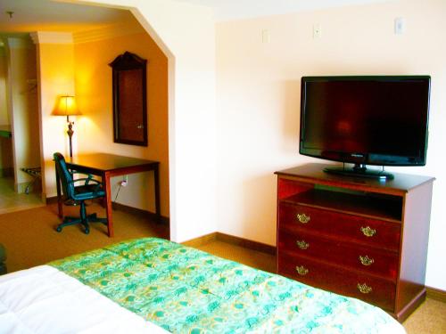 a bedroom with a bed and a television on a dresser at Robinson Inn and Suites in Robinson