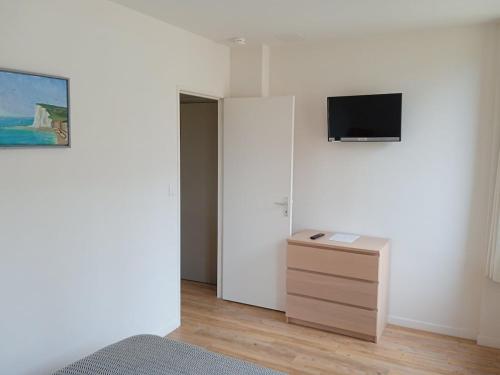 a bedroom with a dresser and a tv on a wall at La Scie - Domaine du Presbytère in La Chapelle-sur-Dun