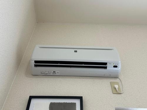 a dvd player sitting on a wall at Stella 202 エアコン付 無料WiFi Netflix in Sapporo