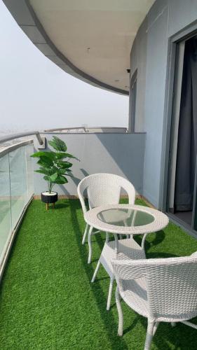 a balcony with white chairs and a table and a plant at supernova spira in Jāmb