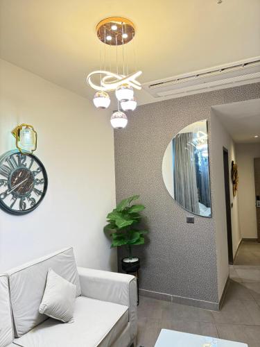 a living room with a couch and a clock on the wall at supernova spira in Jāmb