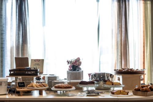 a table filled with different types of pastries and cakes at Grand Hotel Forlì in Forlì