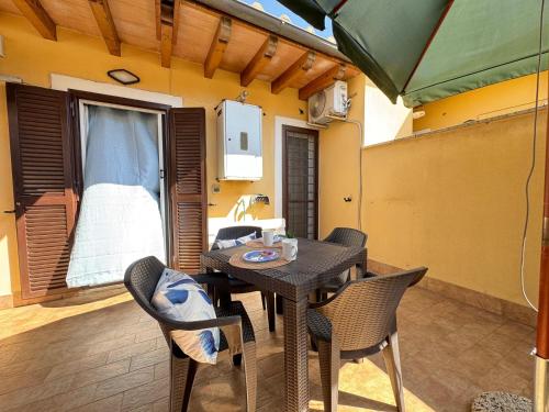 a patio with a table and chairs and an umbrella at Chalet sul Mare in Ladispoli