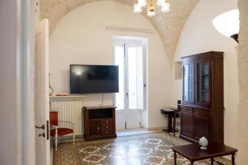 un soggiorno con una TV a schermo piatto su una parete di Il Cuore del Borgo - Terrace In The Old Town a Locorotondo