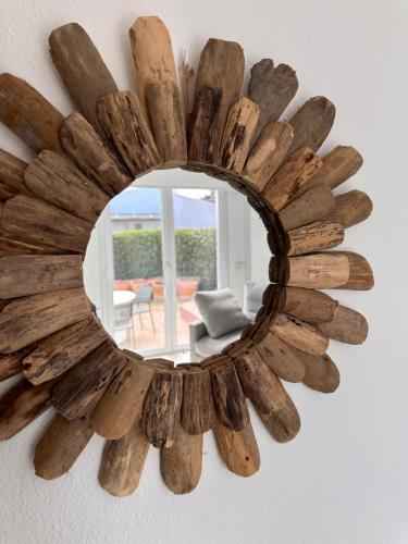 a mirror made out of driftwood hanging on a wall at BINIPARADISE Villas in Binibeca