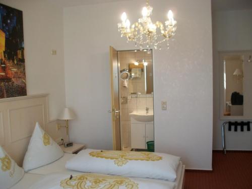 a bedroom with two beds and a chandelier at Kurvilla Fürstin Pauline in Bad Salzuflen