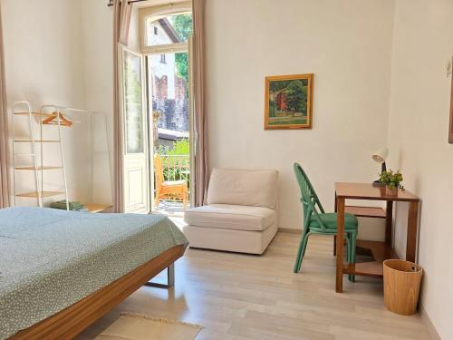 a bedroom with a bed and a chair and a desk at Palacinema Apartment - Locarno Old Town in Locarno