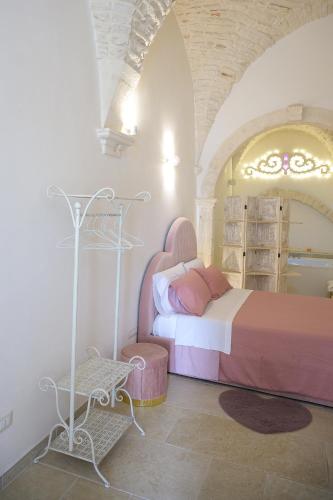a bedroom with a bed and a table in a room at Relais I Quattro Cuori in Martina Franca