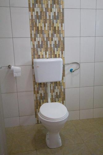 a bathroom with a white toilet in a shower at Havillah Gardens Watamu in Watamu