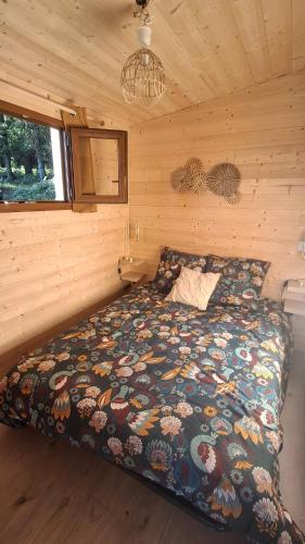 a bedroom with a bed in a log cabin at La ferme de beau soleil Gîte et cabanes in Saint-Gilles-du-Mené