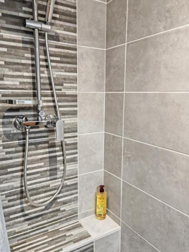 une douche avec une bouteille jaune dans une salle de bain dans l'établissement Romytt Suite, à Saint-Quentin-la-Poterie