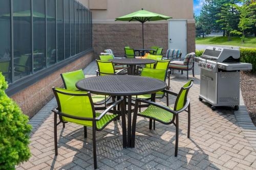 a patio with tables and chairs and a grill at SpringHill Suites Detroit Auburn Hills in Auburn Hills