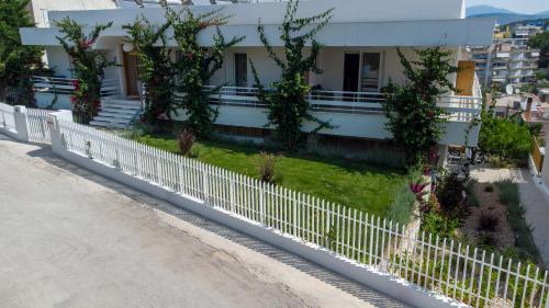 a white picket fence in front of a house at Arancia Elegant Rooms and Suites in Tolo