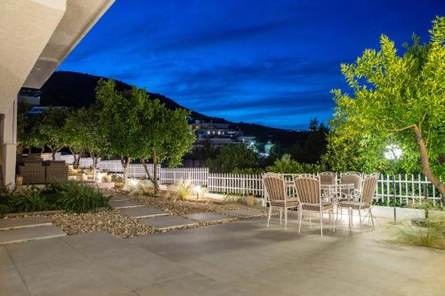 a patio with chairs and a fence at night at Arancia Elegant Rooms and Suites in Tolo