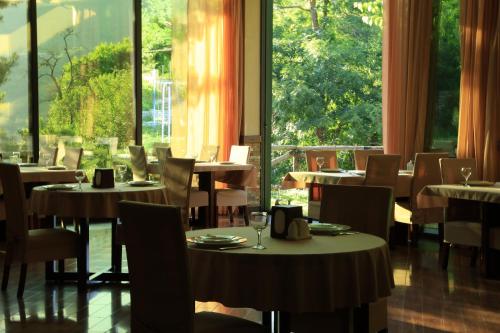 a restaurant with tables and chairs and large windows at Dilijan Park Resort & Villas in Dilijan