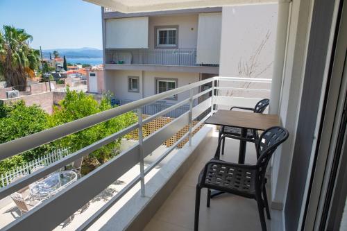 a balcony with a table and chairs and a view at Arancia Elegant Rooms and Suites in Tolo